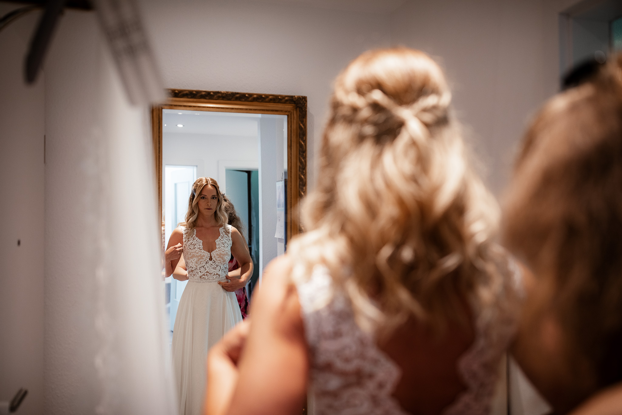 Die Braut schaut sich zum ersten Mal im Spiegel an.